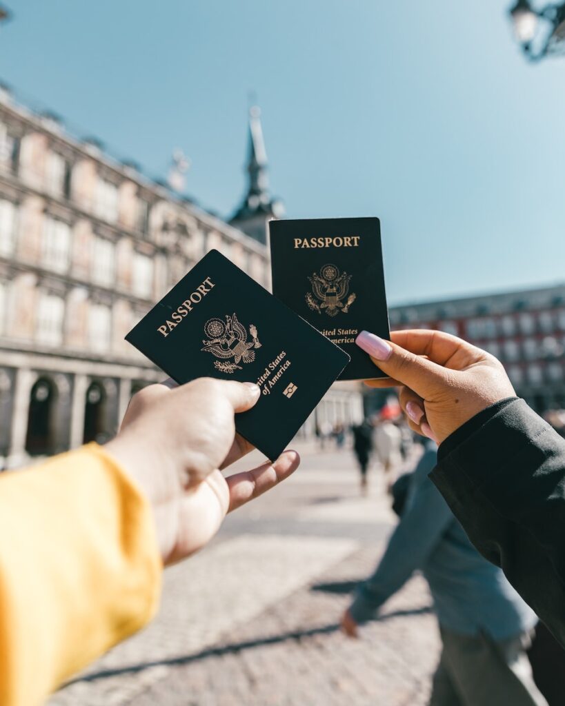  tourists showing US passports on street on sunny day traveling abroad