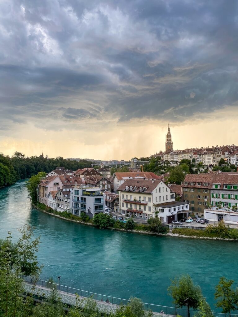 houses near body of water under cloudy sky during daytime