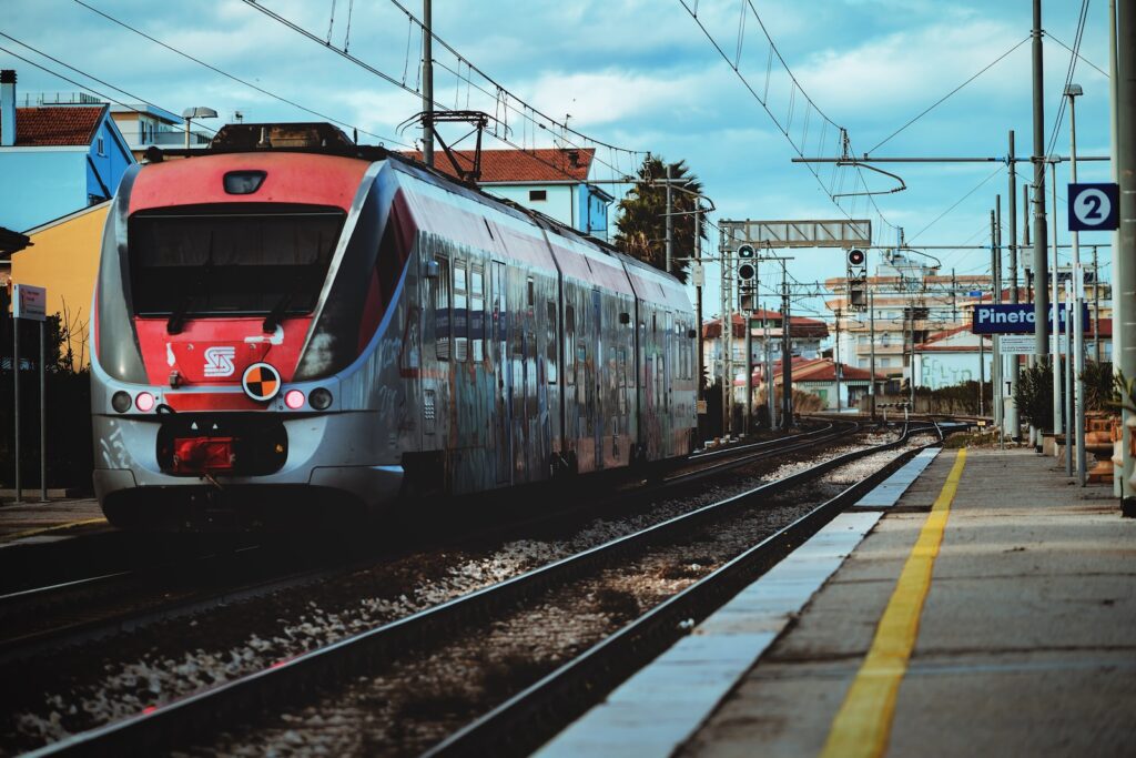 red and white train on rail tracks during daytime