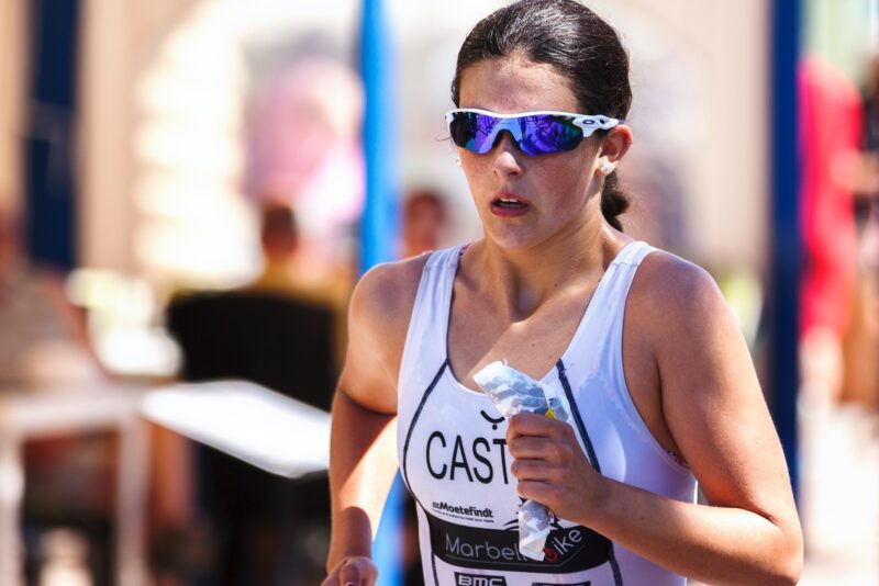 woman wearing blue-lens sunglasses and white tank top