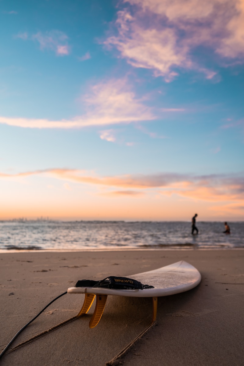 person standing on beach during sunset - best destinations for surfers