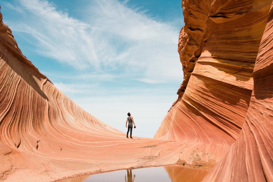 man on antelope canyon during daytime - hiking trails in Utah