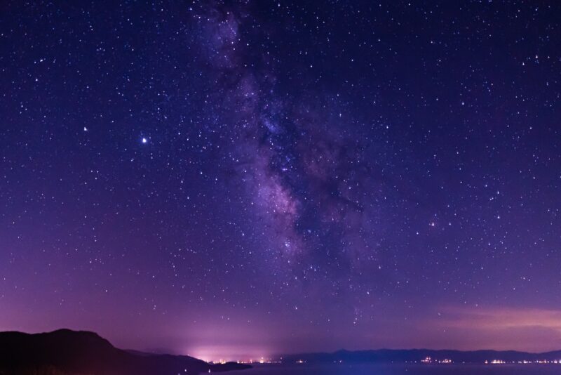 silhouette of mountain under starry night stargazing