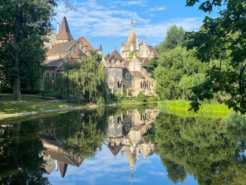 A beautiful European castle surrounded by trees and a body of water