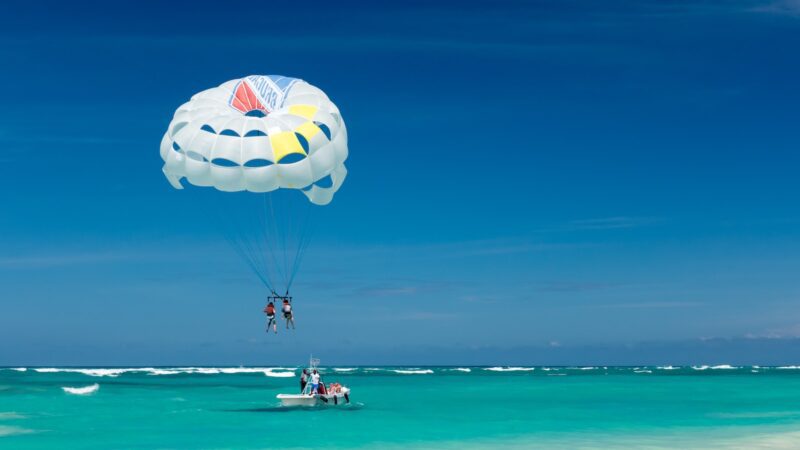 two person riding parachute near beach hang gliding vs paragliding