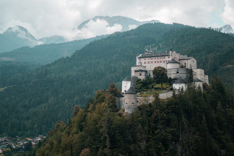 a castle sitting on top of a lush green hillside