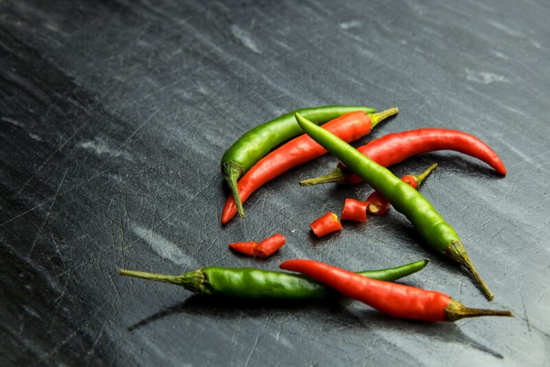 a group of red and green peppers on a table