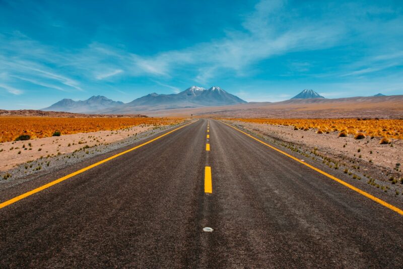 lone road trip going to mountains and blue sky