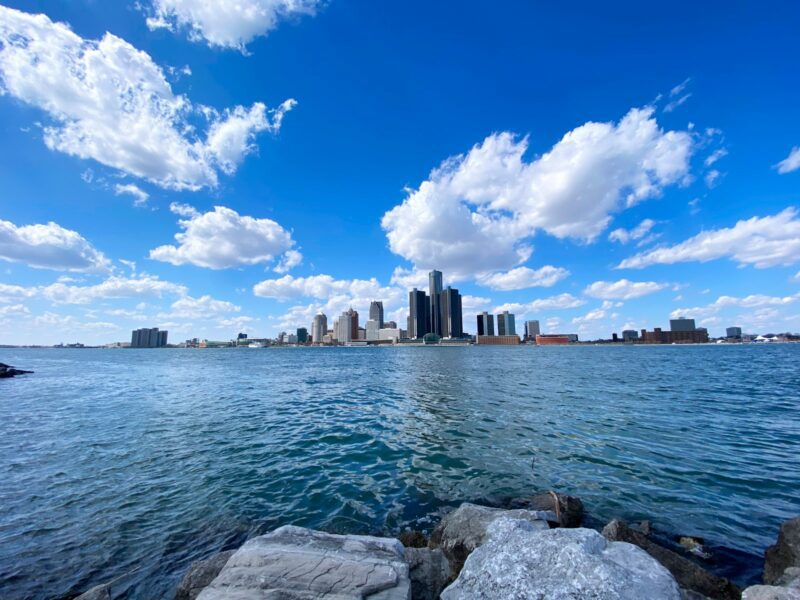 city skyline across body of water under blue and white sunny cloudy sky during daytime