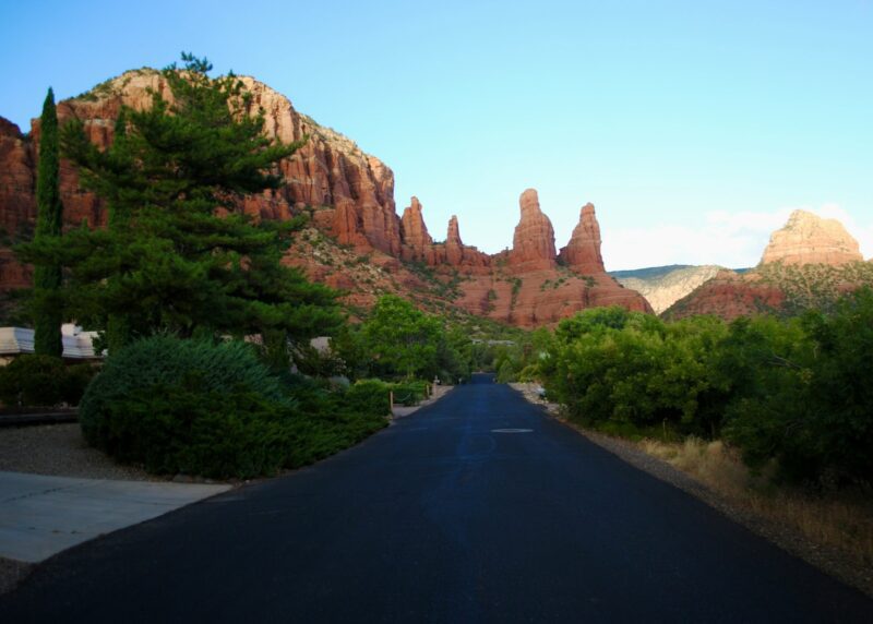 black asphalt road between brown rock formation during daytime