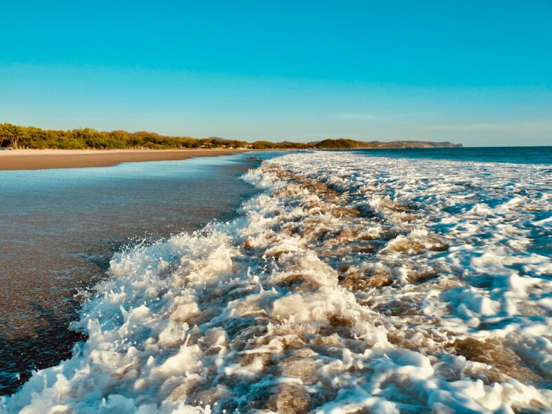 a view of a beach with waves coming in to shore