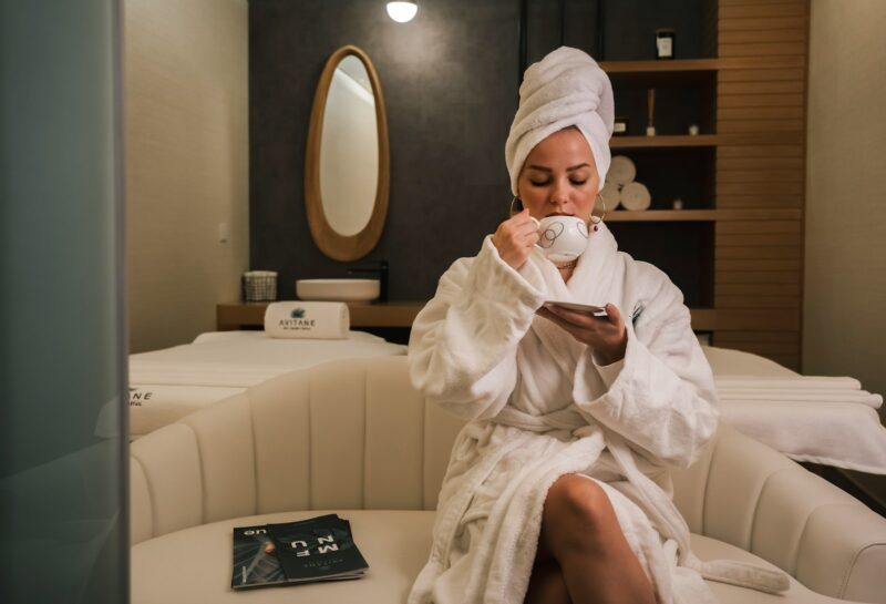 woman in white robe sitting on white couch