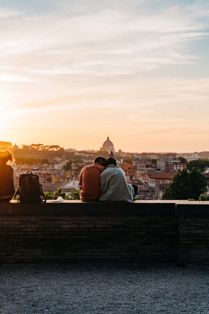 a couple of people sitting on top of a wooden bench