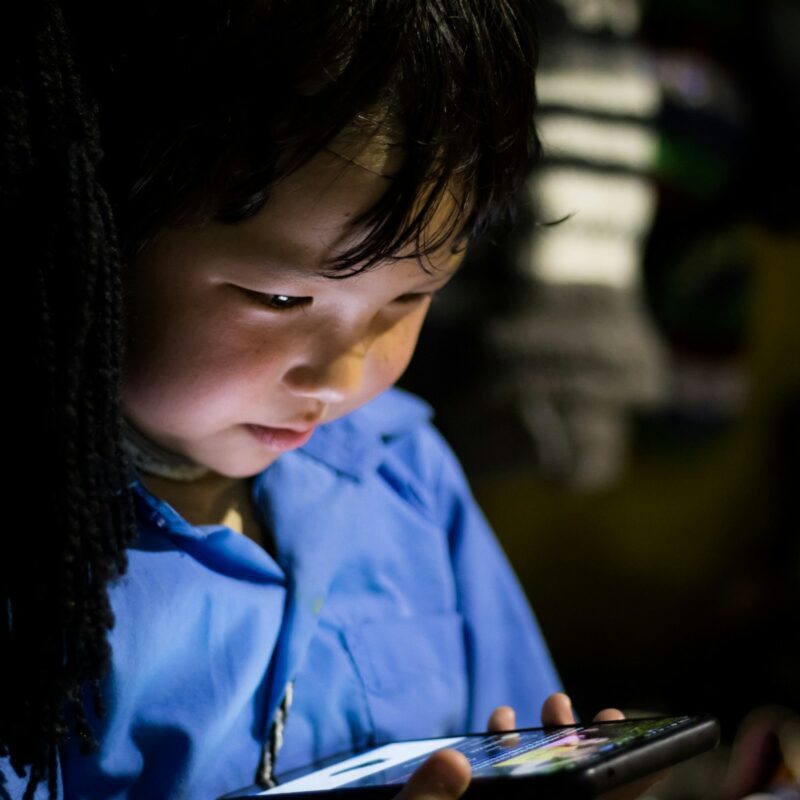 a young child is looking at a tablet