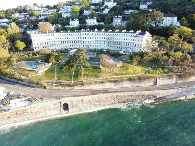 an aerial view of a large white building next to the ocean