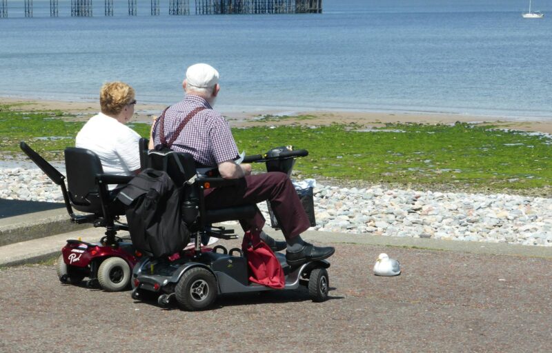 Man and Woman Riding on Red and Black Golf Cart