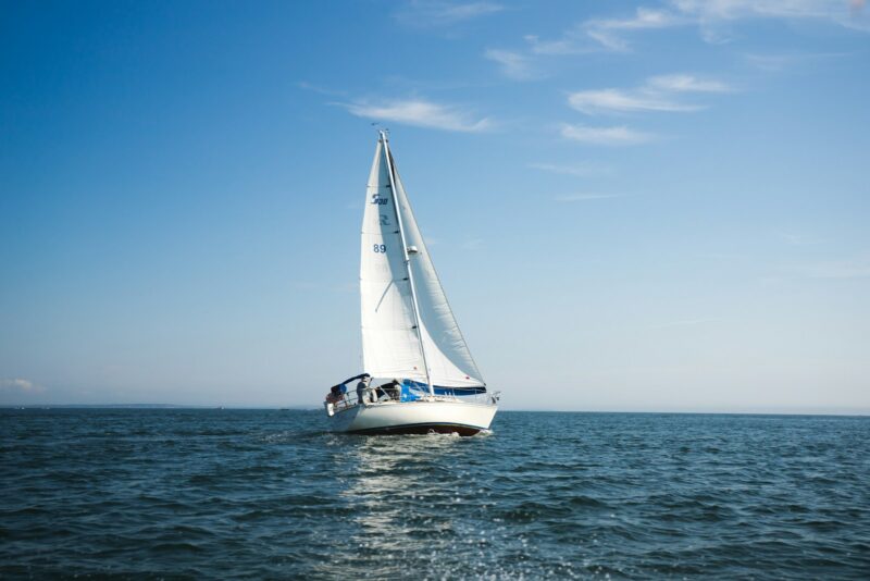 blue and white sailboat on ocean during daytime, eco-friendly sea travel