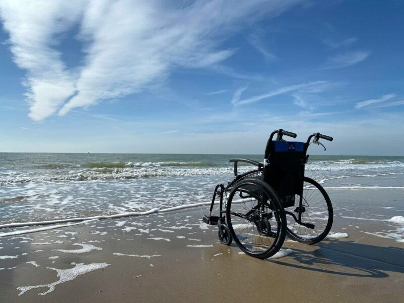 black and gray wheelchair on beach during daytime, accessible destinations