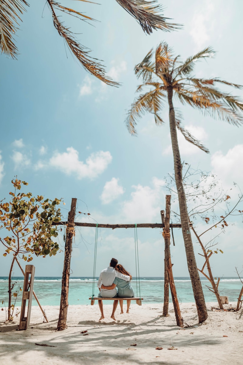 a couple sitting on a bench on a beach, honeymoon sand jar, keepsake